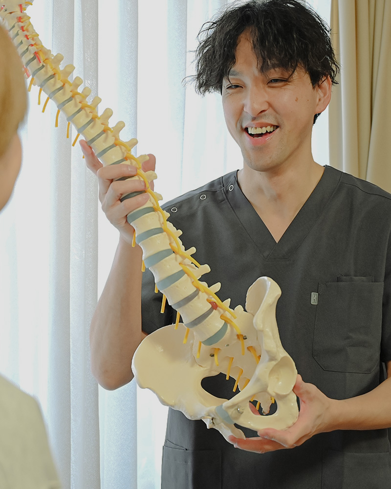 骨格の模型を手に持ち説明する代表